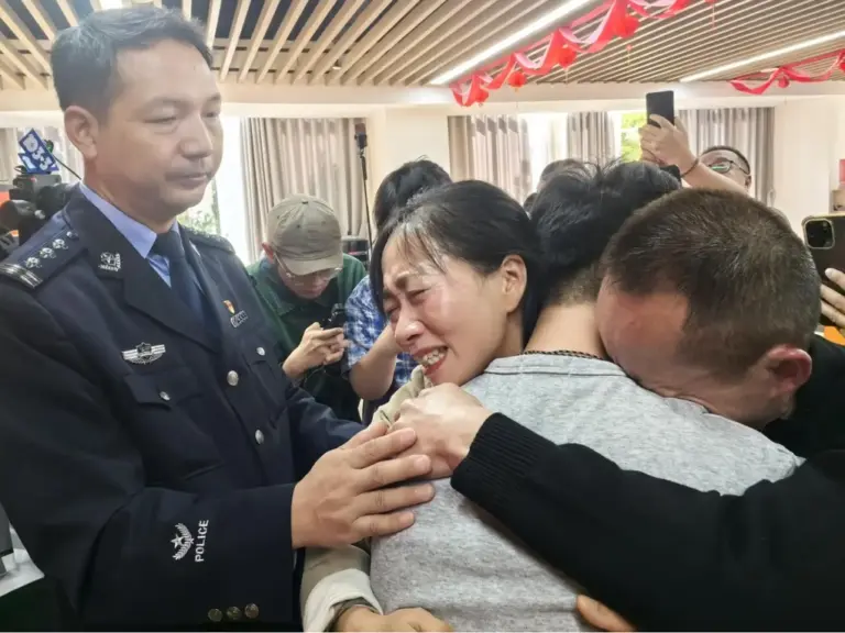 Ông Long và bà Jiang ôm con trai Long Wenyi trong ngày đoàn tụ tại trụ sở Công an thành phố Miên Dương, tỉnh Tứ Xuyên, ngày 20/10. Ảnh: Sohu